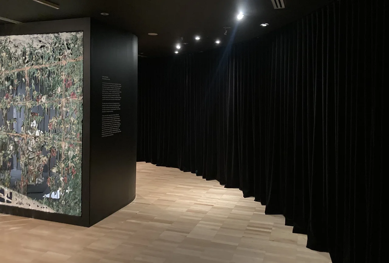 Full-height black S-wave velvet curtains lining a gallery corridor at the NGV Triennial
