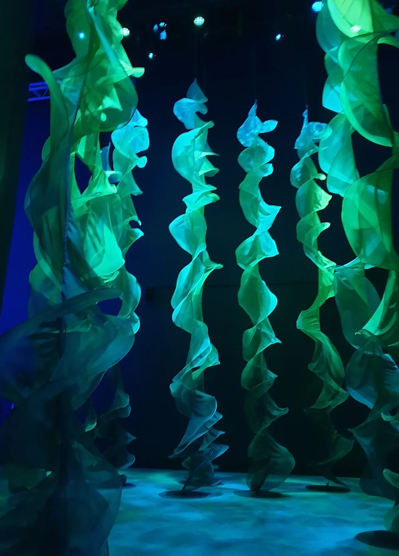 A sculptural green spiral drape installation