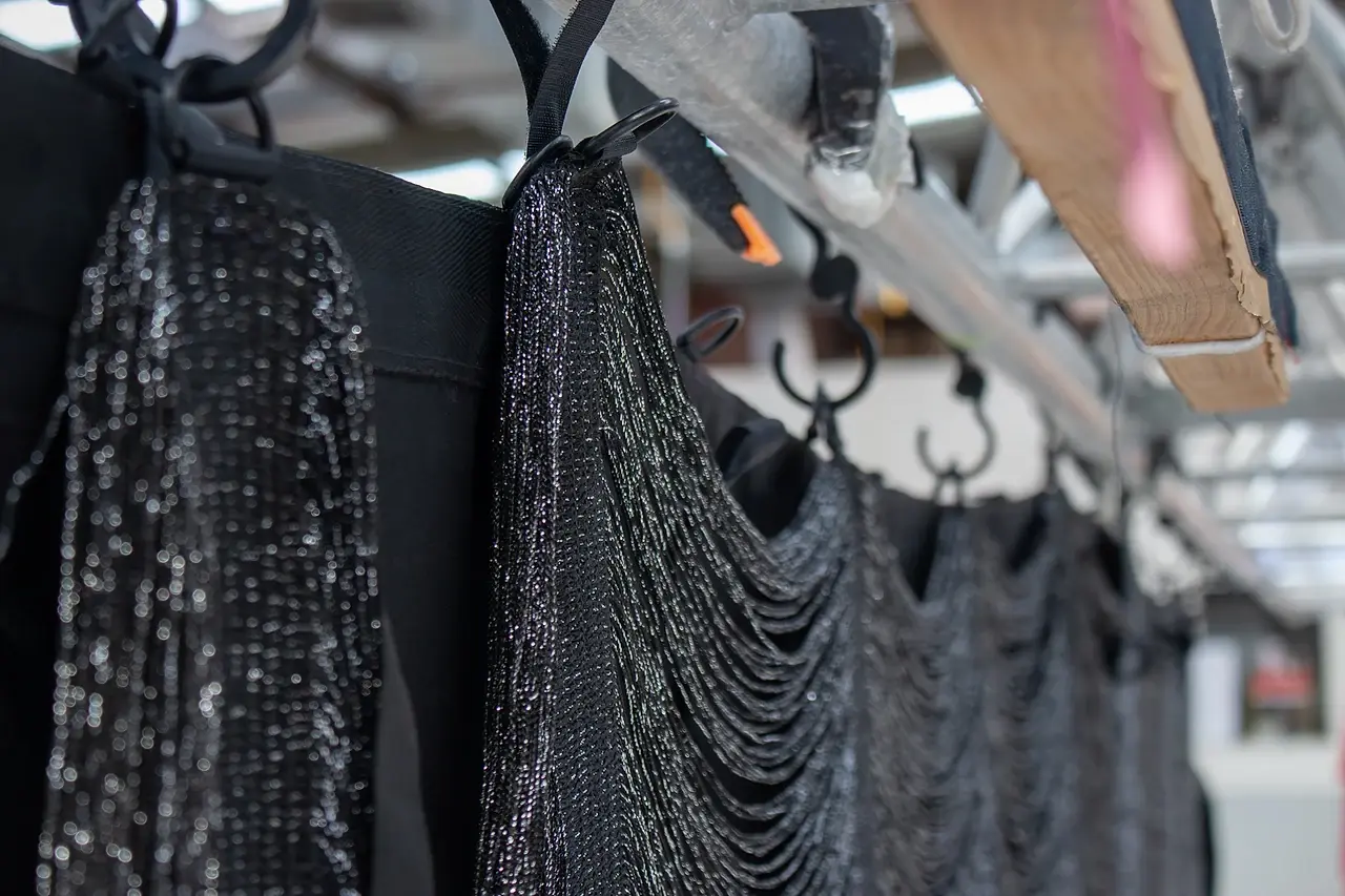 Sequin and metallic festoon drape stock hung on a workshop rail