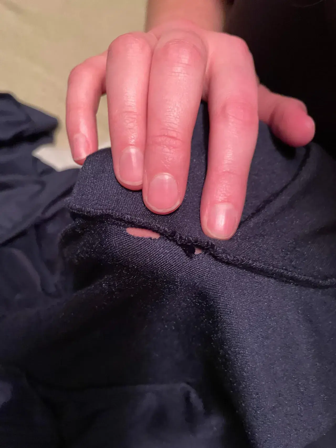 A torn panel and frayed seam on a stage drape, the structural damage that puts a drape past economical repair.
