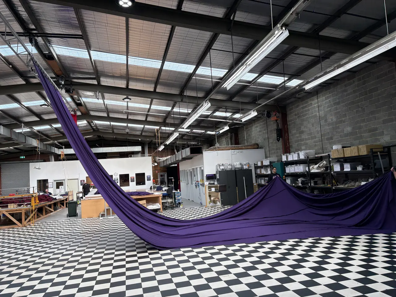 A purple Come Alive roof swag hung from the workshop roof truss and trailing across the floor during a test hang