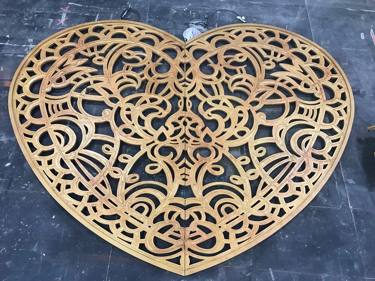 The gold laser-cut filigree heart for one of the Moulin Rouge portals, laid out on the TSA scenic workshop floor. Photo: TSA.